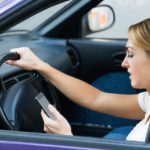 Young woman using cell phone while driving car Young woman using cell phone while driving car