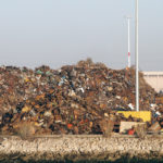 Pile of trash at Recycling processing facility along shore of Oakland Harbor, California during the day. Pile of trash at Recycling processing facility along shore of Oakland Harbor, California during the day.