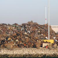 Pile of trash at Recycling processing facility along shore of Oakland Harbor, California during the day. Pile of trash at Recycling processing facility along shore of Oakland Harbor, California during the day.