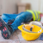 Leg and yellow helmet of injured lying worker at work. Leg and yellow helmet of injured lying worker at work.