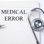 Stethoscope on notebook and pencil with Medical Error words Stethoscope on notebook and pencil with Medical Error words