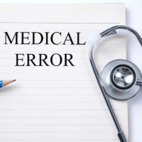 Stethoscope on notebook and pencil with Medical Error words Stethoscope on notebook and pencil with Medical Error words