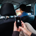 CHIANG MAI,THAILAND - NOV 09, 2017 : A man hand holding Uber app showing on iPhone 6s at destination, Uber is smartphone app-based transportation network. CHIANG MAI,THAILAND - NOV 09, 2017 : A man hand holding Uber app showing on iPhone 6s at destination, Uber is smartphone app-based transportation network.